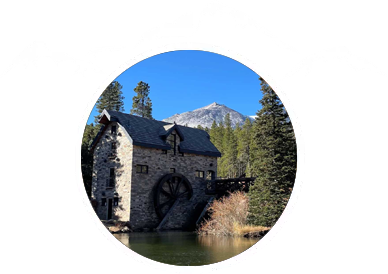 Water mill with trees and mountains at The Salvation Army High Peak Camp Colorado